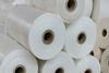 A close-up of thick rolls of polyethylene stacked on top of each other in a warehouse.