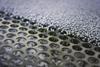 A picture of plastic granules about to be sorted on a perforated screen