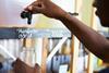 A man is holding a jar beneath a nozzle labelled 'handwash'. He is pumping the liquid into the jar.