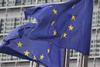 Two EU flags on flagpoles flying in the breeze