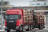 A red Eickelmann truck carries wood timber into UPM's biorefinery construction site.