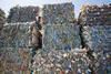 Bales of compressed plastic packaging, ready to be recycled and processed.