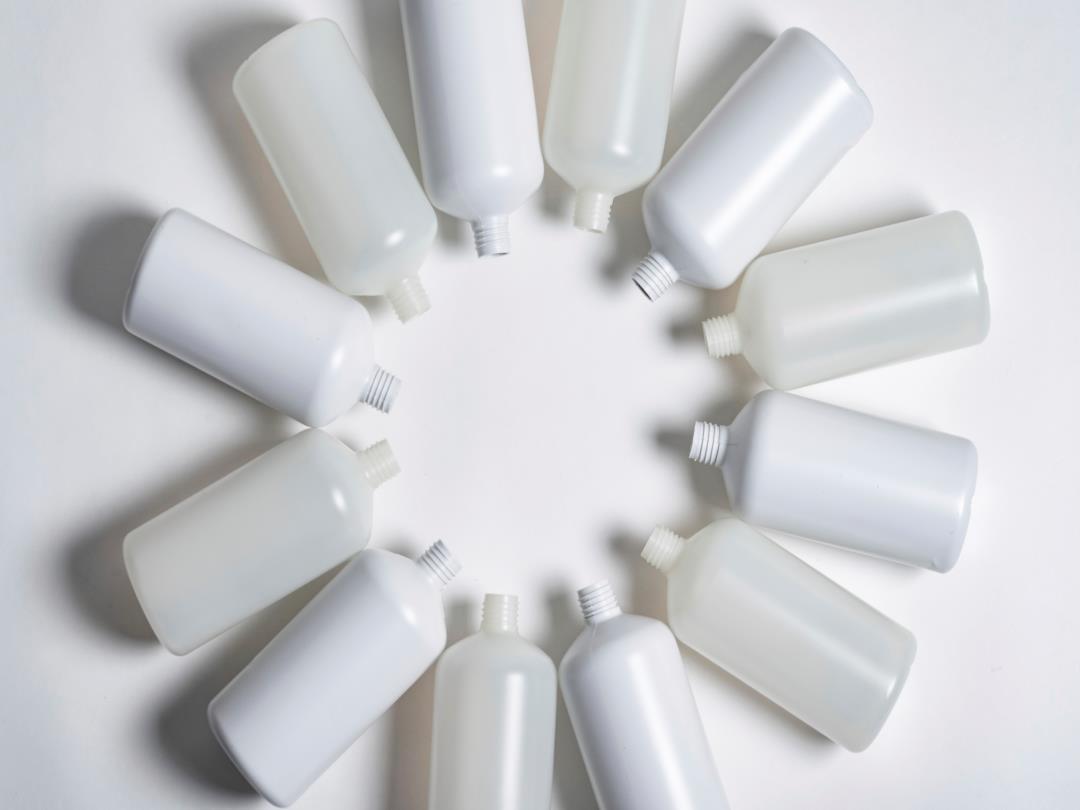A series of plastic bottles, all without lids, have been sorted into a circular formation with their necks facing inwards.…