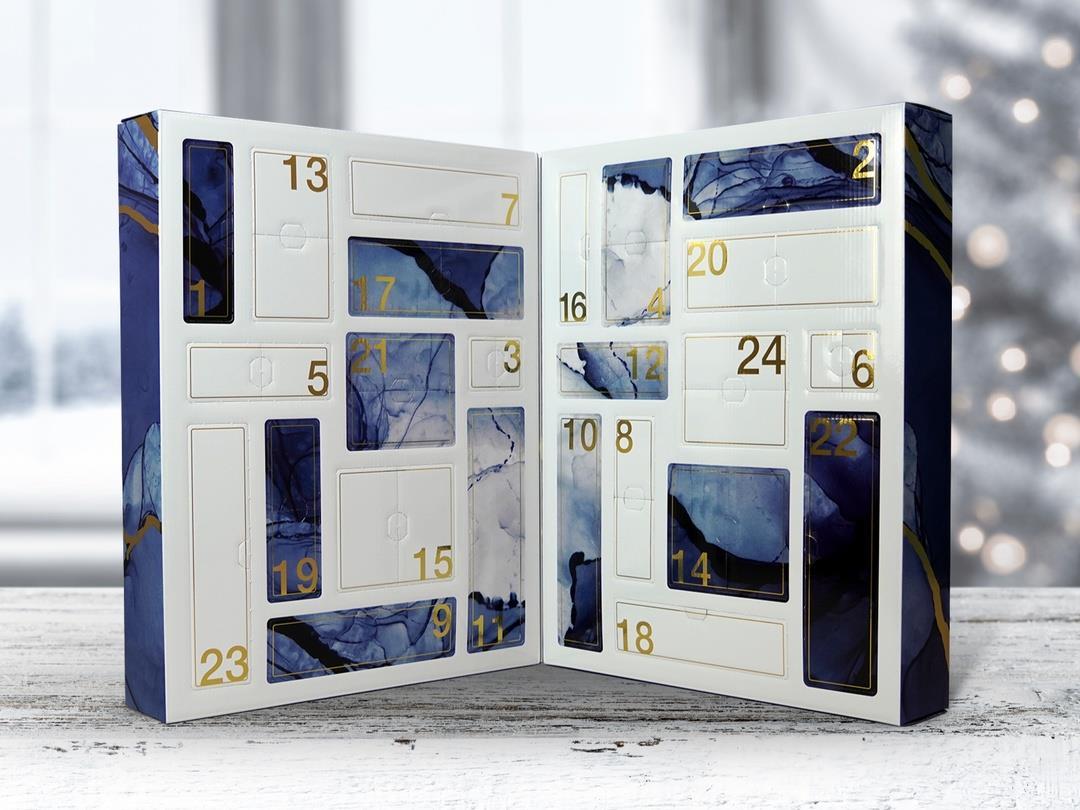 A thick advent calendar folds in the middle to create a compact box. It is propped open to reveal a series of white and…