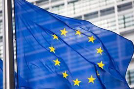 The flag of the European Union, flying in front of the EU parliament building.