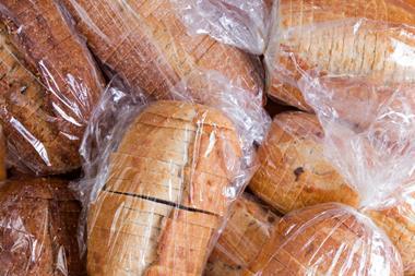 A pile of loaves of sliced bread. Each is individually wrapped in transparent plastic film.