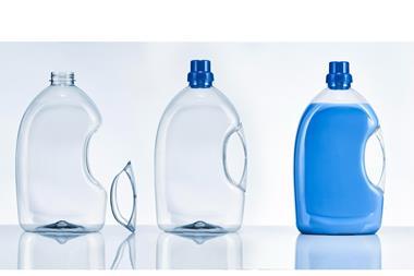 Three PET plastic bottles are lined up in a row. The left and middle are empty, although the latter's handle and lid have been separated from the bottle. The bottle on the right is lidded, the handle is attached, and it is filled with blue liquid.
