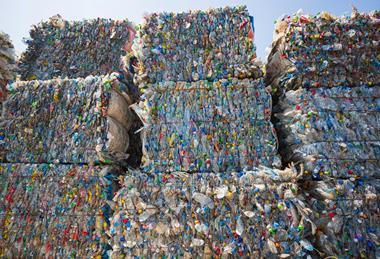 Bales of compressed plastic packaging, ready to be recycled and processed.
