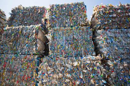 Bales of compressed plastic packaging, ready to be recycled and processed.