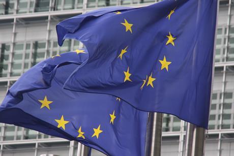 Two EU flags on flagpoles flying in the breeze