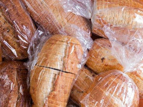 A pile of loaves of sliced bread. Each is individually wrapped in transparent plastic film.