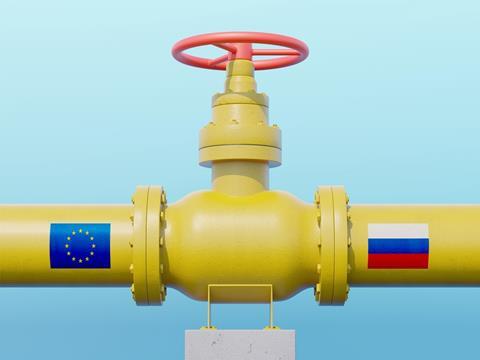 A yellow gas pipeline meets at a valve in the middle. On the left pipe is the EU flag, on the right is the Russian flag.