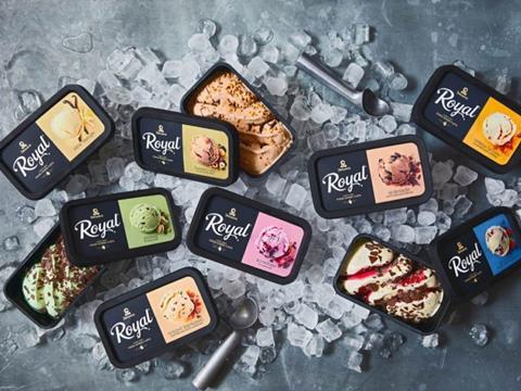 A large pile of ice cubes has been arranged on a metal surface. On top of it are two ice cream scoopers in amongst various black ice cream tubs with Diplom-IS Royal branding. Some of the boxes have been opened to reveal the ice cream inside.