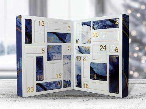 A thick advent calendar folds in the middle to create a compact box. It is propped open to reveal a series of white and blue 'windows', each one labelled with a number corresponding with a day in December.